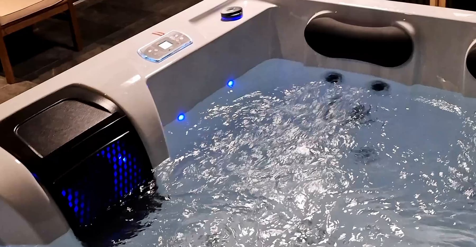Sprudelnder Whirlpool mit Wasserfall und blauem Farblicht