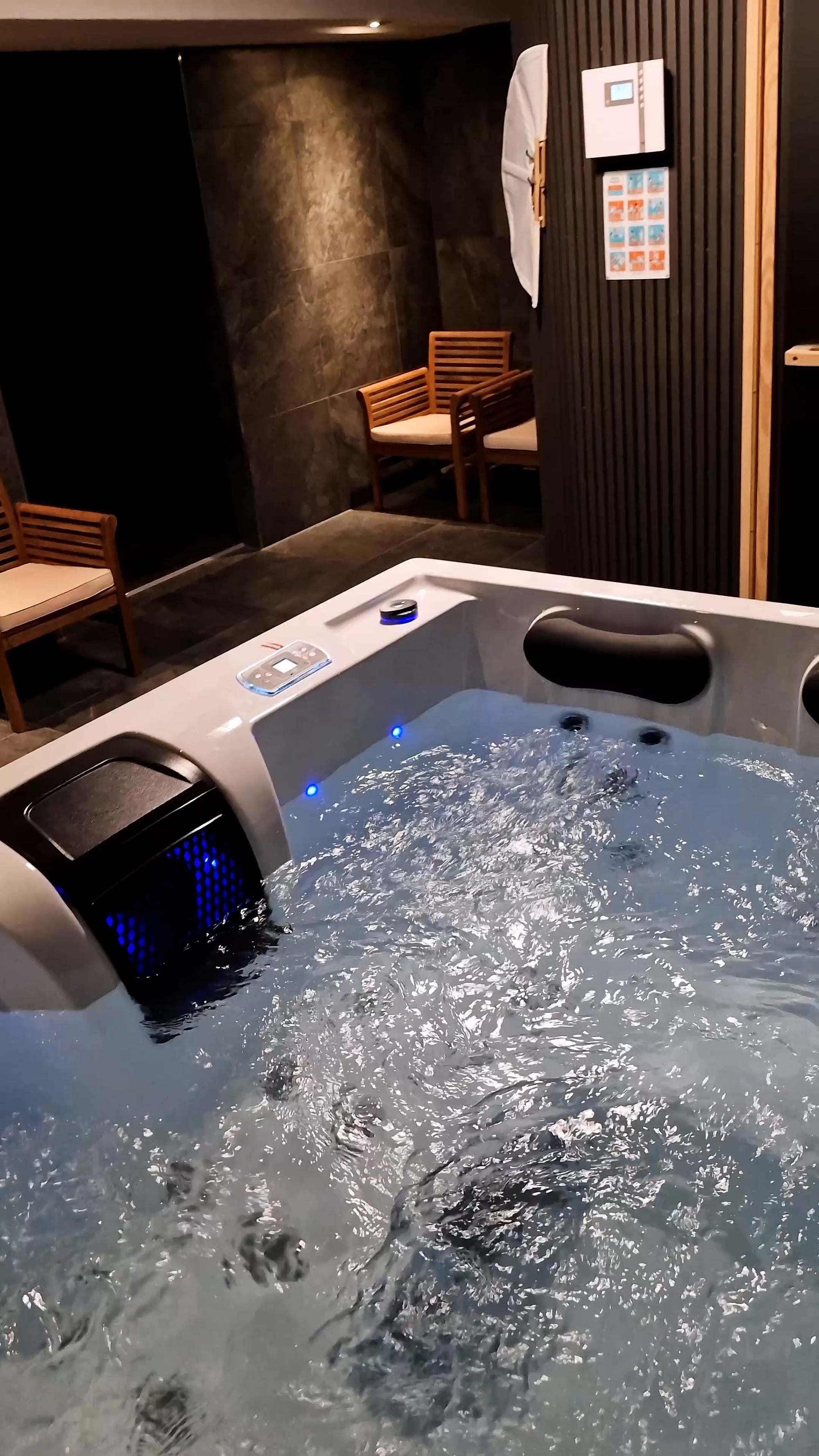 Sprudelnder Whirlpool mit Wasserfall und blauem Farblicht